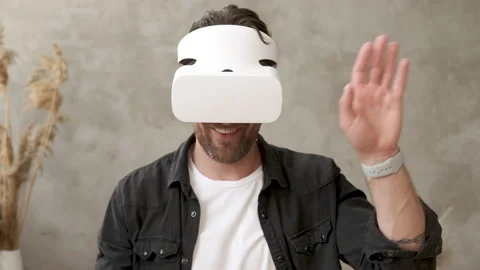 Handsome man wearing virtual reality headset having online video chat conference Video stock 133685374