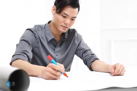 Handsome man while working on a project sitting behind a desk Stock Photos