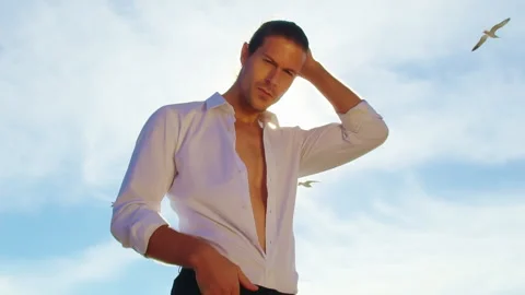 Handsome man in white shirt posing against sun blinks. Man touching his face Stock Footage 245950840