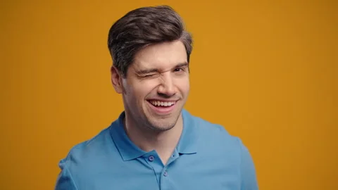 Handsome Man Winking Eye, Flirting, Smiling To Camera. Guy In Studio On Yellow Stock Footage 312890641