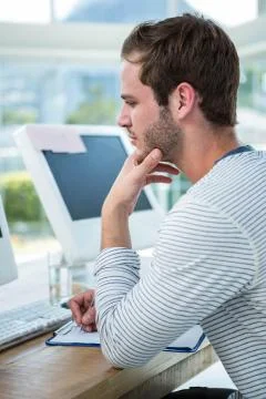Handsome man working on computer and taking notes 스톡 사진