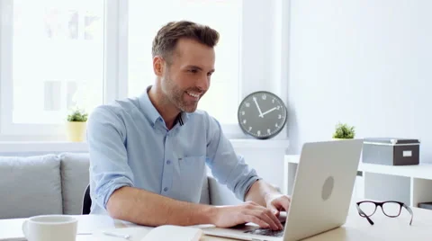 Handsome man working at home office on laptop Stock Footage