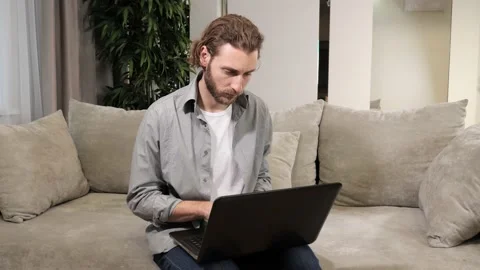 Handsome Man Working on Laptop Computer while Sitting on the Couch at Home. Stock-Footage 167204885