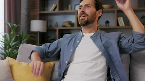 Handsome man working on laptop while sitting on sofa in stylish apartment. Relax Video stock 209514194