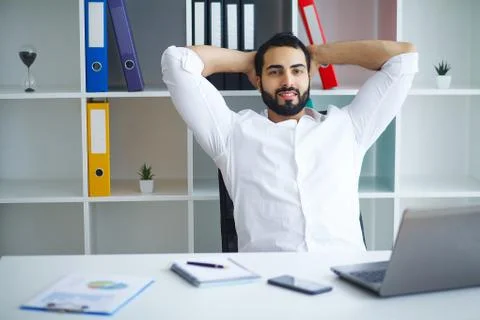 Handsome man working on project at modern office desk Stock Photos
