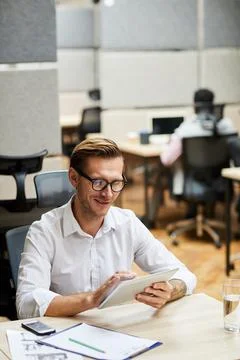Handsome manager viewing sales data on tablet Stock Photos