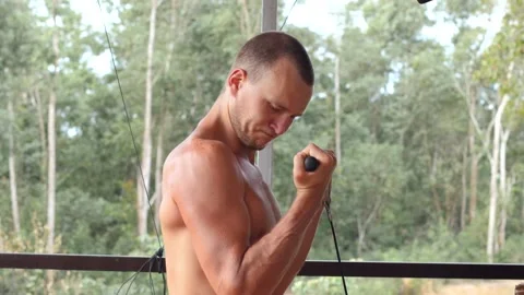 A handsome masculine man doing exercise for arms in the gym outdoor background. Stock Footage 149554392