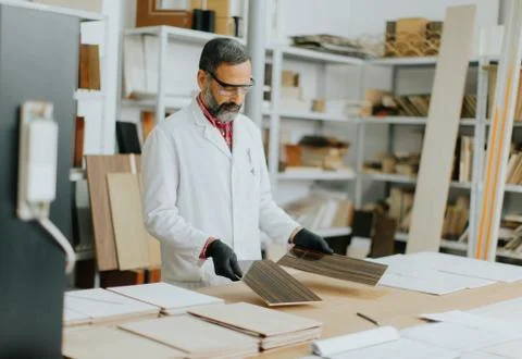 Handsome mature engineer testing colors on wooden specimens 스톡 사진