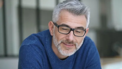 Handsome mature man looking at camera in modern home Stock Footage 104189042