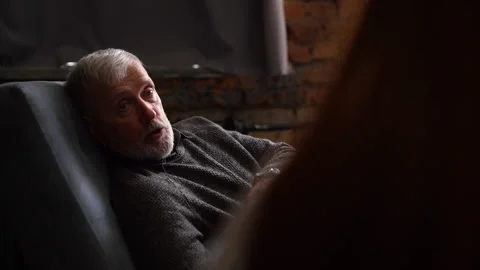 Handsome mature man lying on couch and talking about his problems with Stock-Footage 136506193