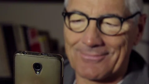 Handsome mature man using smartphone at home Video stock 74823030