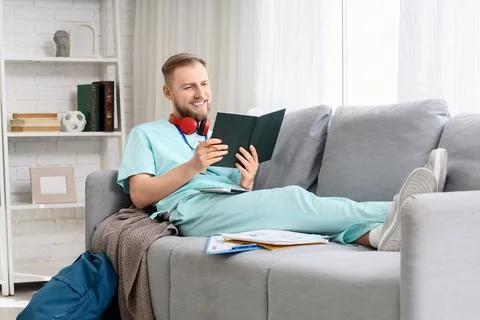 Handsome medical intern studying with notebook on sofa in clinic Stock Photos