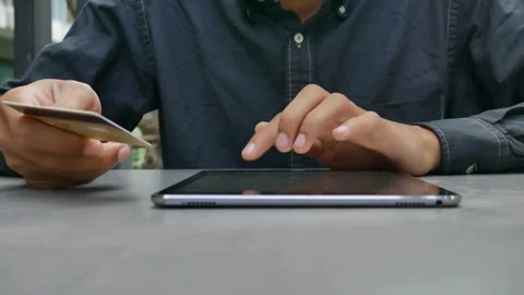 Handsome men is making online payment holding bank card using modern laptop Stock Footage 265929623