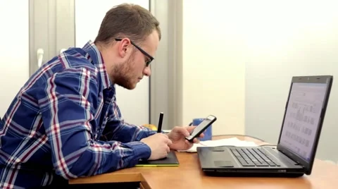 Handsome men sitting behind the desk and using computer.. Stock Footage 49057769