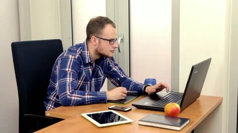 Handsome men sitting behind the desk and using computer.. Stock-Footage 49058015
