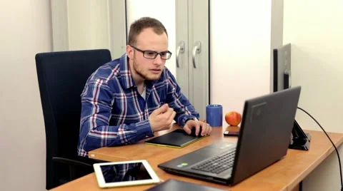 Handsome men sitting behind the desk and using  two computers at the same time Stock-Footage 49058016