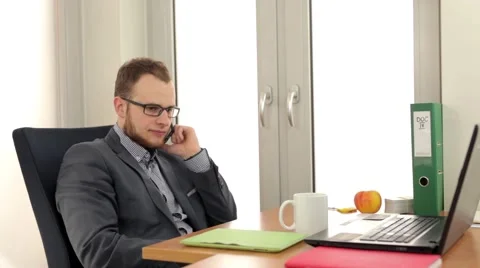 Handsome men sitting behind the desk and talking by the phone (27) Stock Footage 49339350