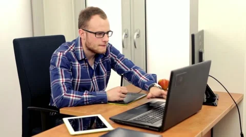Handsome men sitting behind two computers, he is so busy Stock Footage 49058322