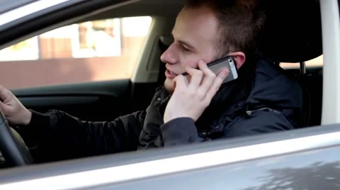 Handsome men sitting inside his car and making converstation by the cellphone Stock Footage 49338552