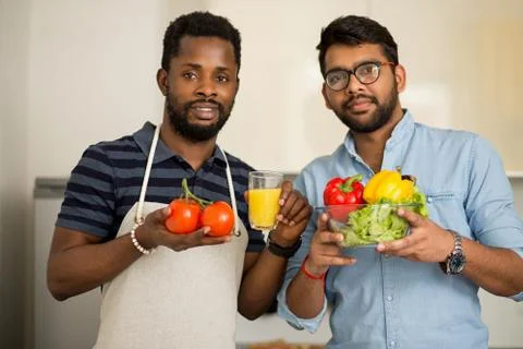Handsome men standing in kitchen Stock Photos