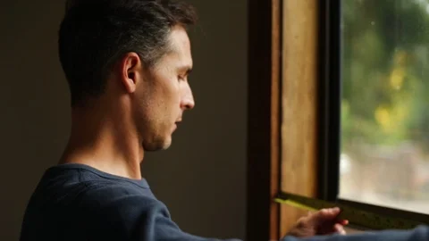Handsome middle-aged builder concentrates on measuring the window frame with a 库存影片 88404986