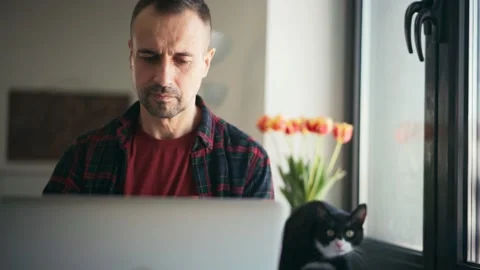 Handsome middle-aged man busy typing on a laptop while working from home Stock-Footage 149094519