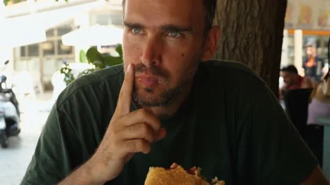 A handsome middle-aged man eats a Stock Video Pond5