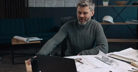 Handsome middle aged man sitting at the workplace in the Office and looking Stock Footage 126244962