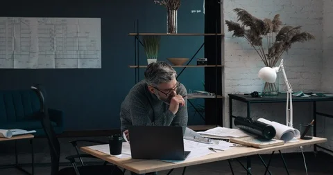 Handsome Middle aged man standing in his Modern Office and making blueprints Vídeo Stock 126244571