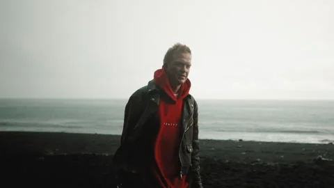 Handsome middle-aged man standing on Reynisfjara Black Sand Beach, Iceland Stock Footage 253690635