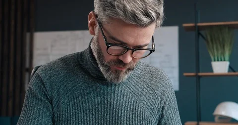 Handsome middle Aged Man with Stylish Eyeglasses sitting at his Modern Office Stock Footage 126243214