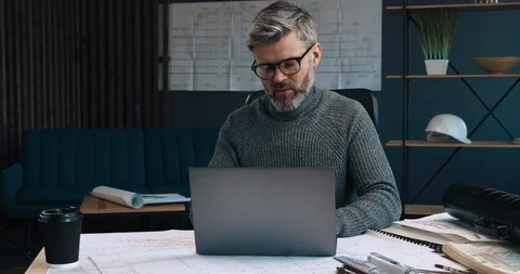 Handsome middle Aged man working at his Modern Office, sitting at the desk full Stock Footage 126243845