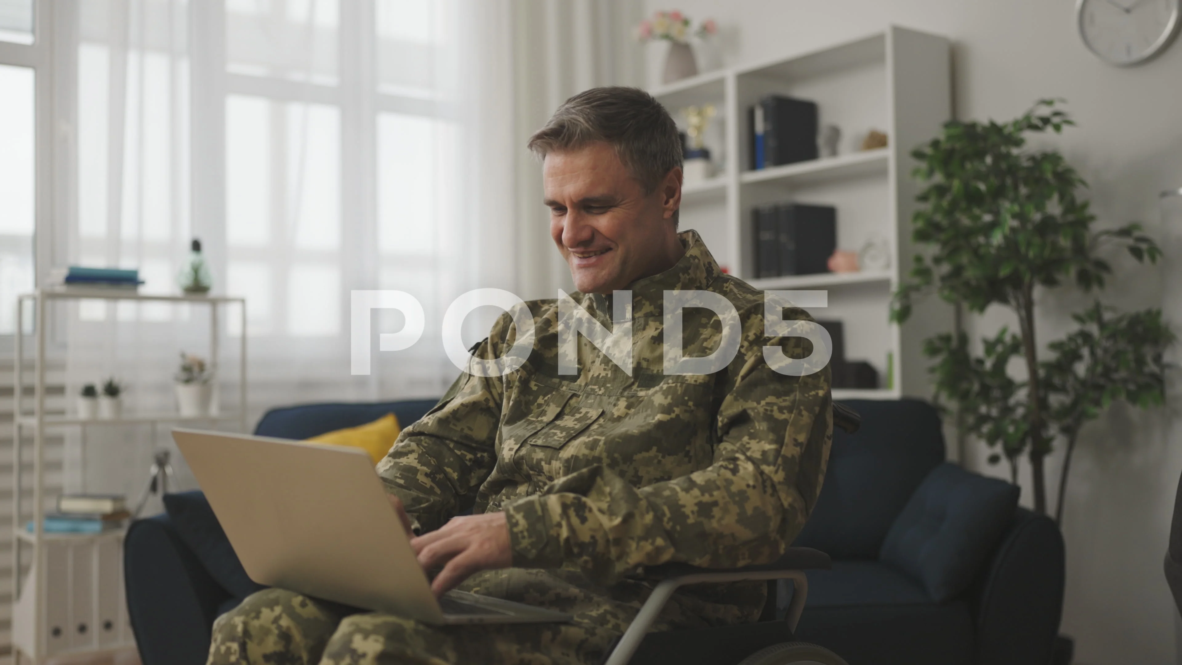 Handsome military man with disability having video call with a friend on  laptop