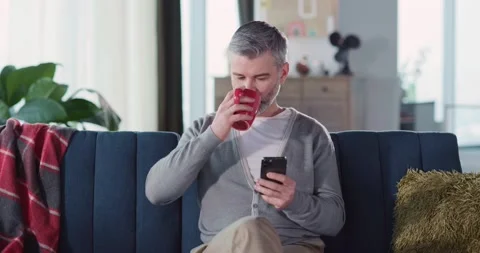Handsome millennial guy using mobile phone in the living room. Businessman adult Video stock 149264333