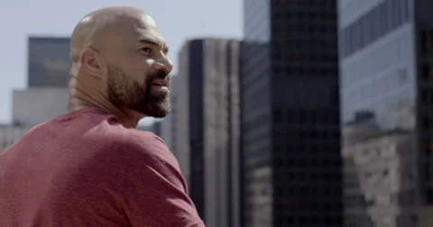 Handsome mixed race man looking thoughtfully at big city buildings 4K Stock Footage 64644838
