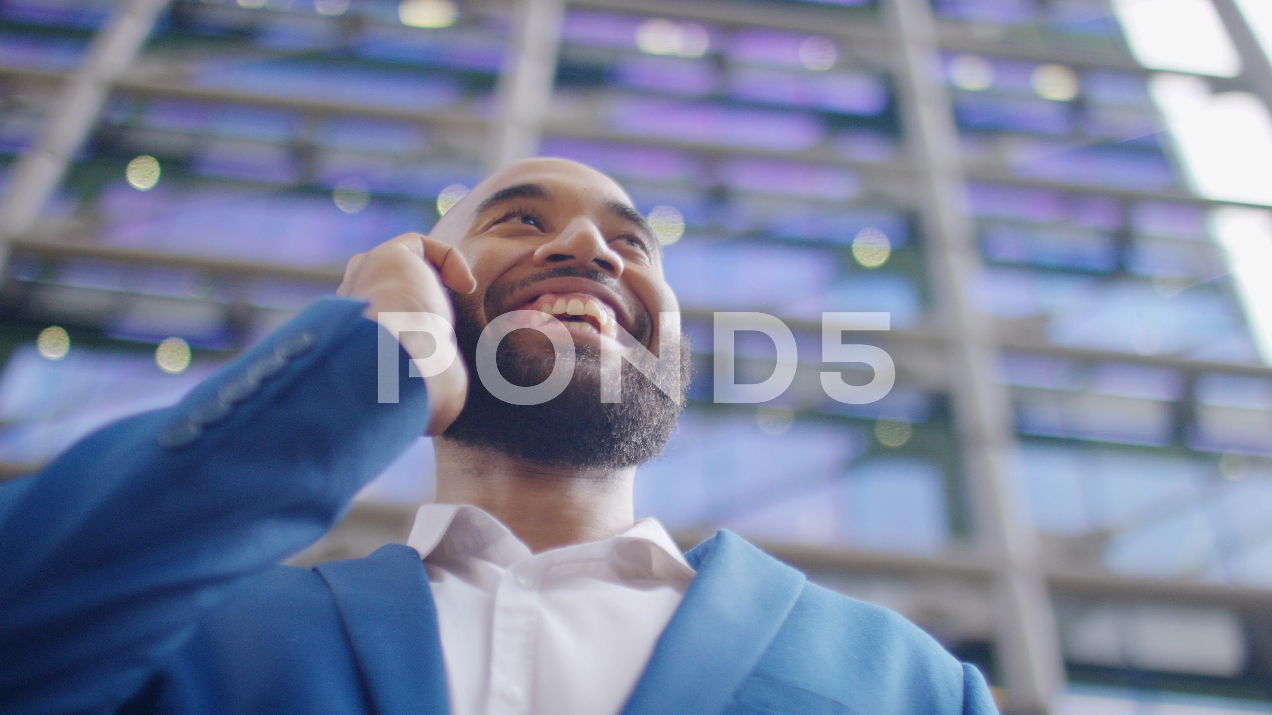 Handsome mixed race man in a suit talking on his phone in the city