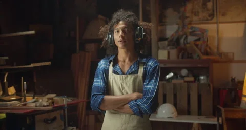 Handsome model Latin curly guy carpenter in anti-noise headphones at workshop Stock Footage 140531342