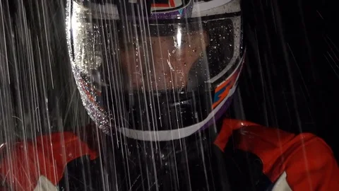 Handsome motorcycle driver in helmet in the rain. Close up. Stock Footage 80252665