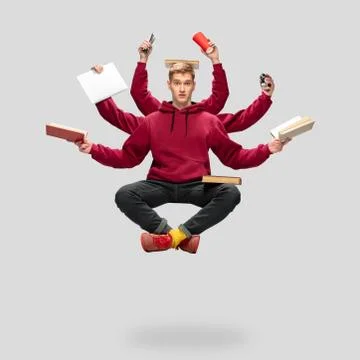 Handsome multi-armed student levitating isolated on grey studio background with Stock Photos