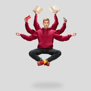 Handsome multi-armed student levitating isolated on grey studio background with Stock Photos