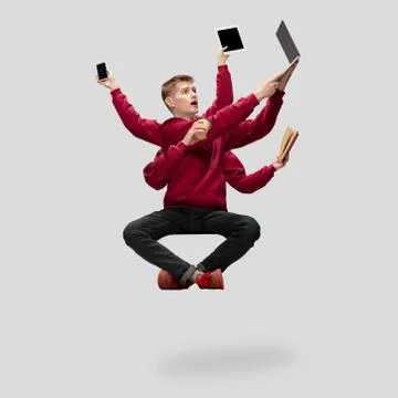 Handsome multi-armed student levitating isolated on grey studio background with Stock Photos