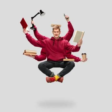 Handsome multi-armed student levitating isolated on grey studio background with Stock Photos