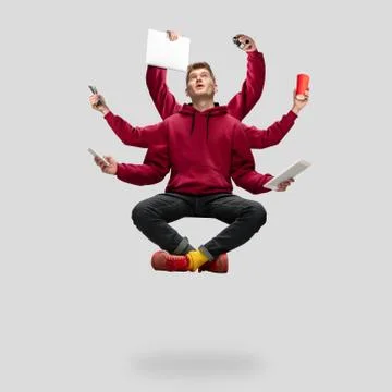 Handsome multi-armed student levitating isolated on grey studio background with Stock Photos
