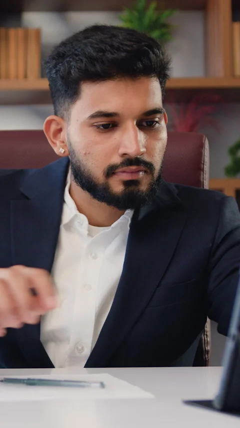 Handsome multitasking Indian businessman in formal suit working using the touchp Stock Footage 325054501