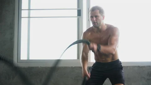 Handsome Muscular bodybuilder man exercises with battle ropes at gym . Shirtl Stock Footage 162805460