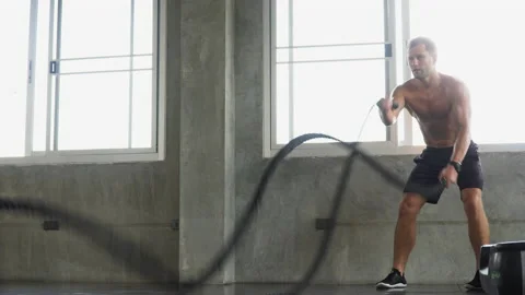 Handsome Muscular bodybuilder man exercises with battle ropes at gym . Shirtl Stock Footage 162805581