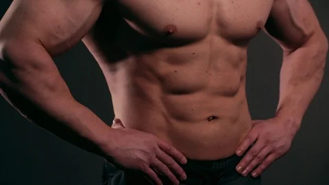 Handsome muscular bodybuilder posing over black background Stock Footage