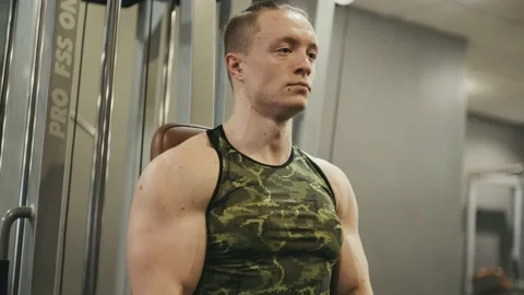 Handsome muscular man doing exercise with a heavy barbell in gym Stock Footage 229988231