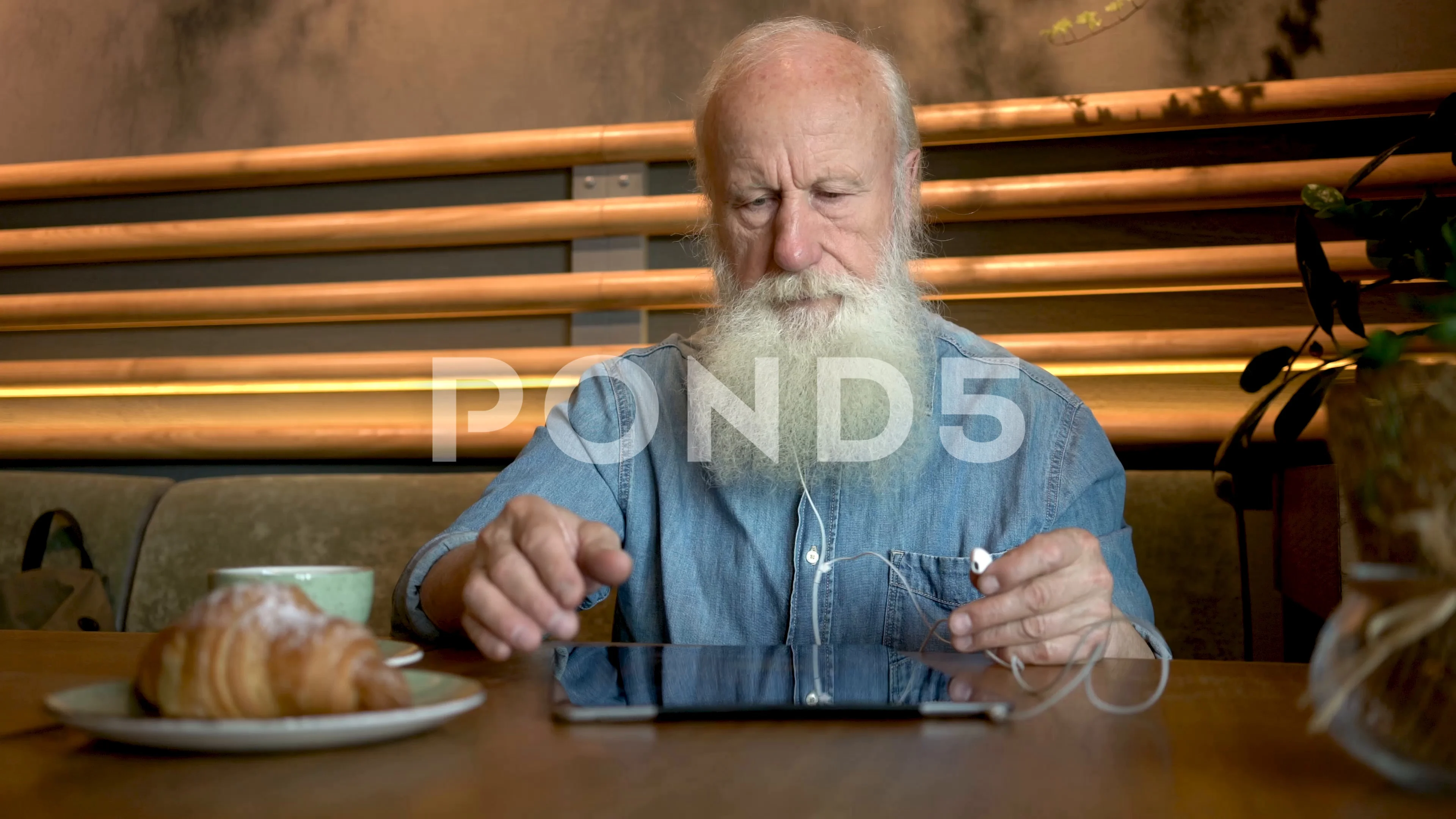 handsome old man with tablet computer in cafe. 4K