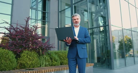 Handsome older man entrepreneur using laptop remotely computer for online busine Stock Footage 331153519